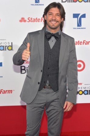 Melvin Cabrera <br /><br />El actor optó por el gris y el negro combinados de una forma muy peculiar en un equipo de chaqueta, chaleco, pantalones y corbatín.