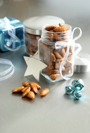 Recipientes con dulces o nueces y decorados con cintas.