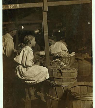 Niña seleccionando material en una fábrica.