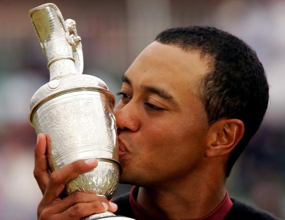 El astro del golf Tiger Woods le da un beso al fruto de su esfuerzo como deportista.