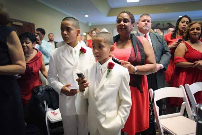 WEST PALM BEACH, FL - FEBRUARY 14: Familiy members look on during a group Valentine's day wedding at the National Croquet Center on February 14, 2013 in West Palm Beach, Florida. The group wedding ceremony is put on by the Palm Beach Country Clerk & Comptroller's office and approximately 40 couples tied the knot. (Photo by Joe Raedle/Getty Images)