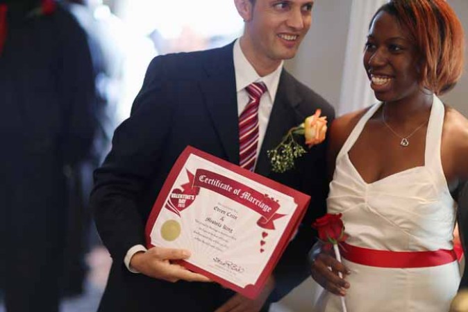 WEST PALM BEACH, FL - FEBRUARY 14: Evan Cetin and Michelle Renne (L-R) hold their marriage certificate after being wed during a group Valentine's day wedding at the National Croquet Center on February 14, 2013 in West Palm Beach, Florida. The group wedding ceremony is put on by the Palm Beach Country Clerk & Comptroller's office and approximately 40 couples tied the knot. (Photo by Joe Raedle/Getty Images)