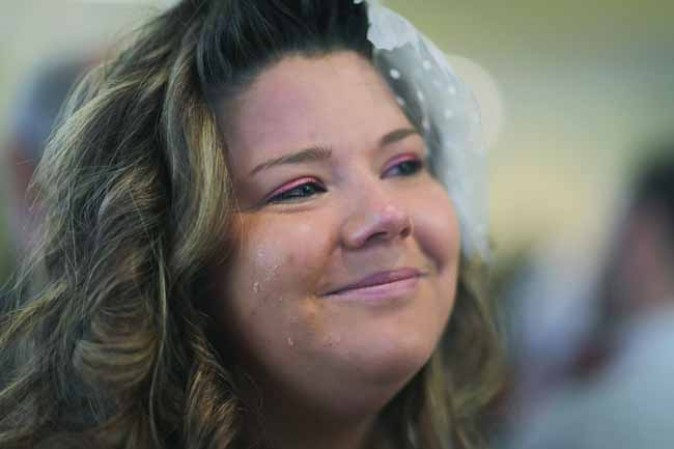 WEST PALM BEACH, FL - FEBRUARY 14: Ashley Homa sheds tears as she is wed to Robert Homa during a group Valentine's day wedding at the National Croquet Center on February 14, 2013 in West Palm Beach, Florida. The group wedding ceremony is put on by the Palm Beach Country Clerk & Comptroller's office and approximately 40 couples tied the knot. (Photo by Joe Raedle/Getty Images)