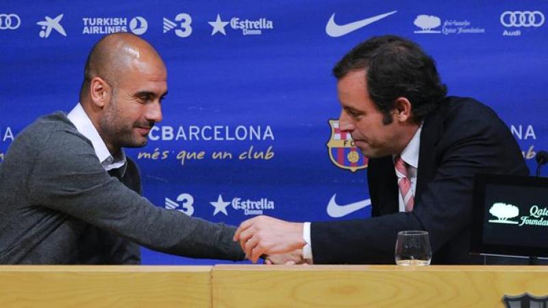 Josep Guardiola saluda al presidente del Barsa Sandro Rosell durante la conferencia de prensa en la que anunció que ya no dirigirirá al equipo.