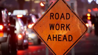 Road work sign on a street with heavy traffic.