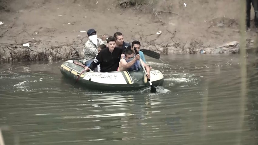 Grupo de personas cruzando el río en balsa.