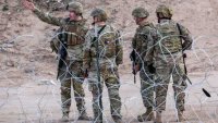 CIUDAD JUAREZ, MEXICO – JANUARY 07: Texas National Guard soldiers stand guard at the U.S.-Mexico border on January 07, 2023 as viewed from Ciudad Juarez, Mexico. U.S. President Joe Biden is set to visit El Paso on January 8th, his first visit to the border since he became president two years before. U.S. Border authorities took into custody some 2.5 million migrants in 2022, the highest number on record. (Photo by John Moore/Getty Images)