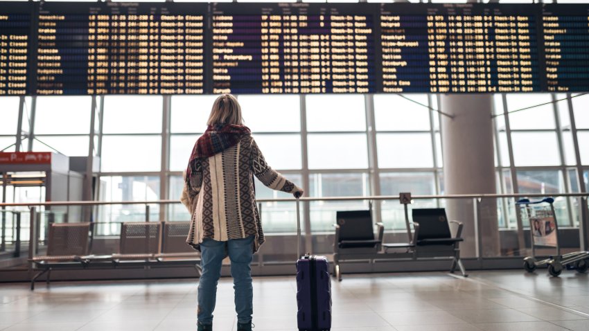 Woman reading departure board on airport