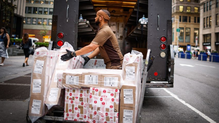 NEW YORK, NEW YORK – AUGUST 07: A UPS worker unloads boxes from a truck parked on a street in Midtown Manhattan on August 07, 2023 in New York City. The consensus EPS estimate is $2.50 and the consensus revenue estimate is $23.12 billion.UPS has beat the EPS consensus the past 12 quarters but revenue estimates the past three quarters. (Photo by Kena Betancur/VIEWpress)