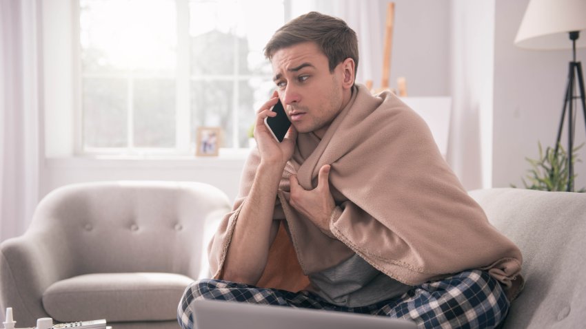 I am sick. Sad young man talking on the phone to his employer while asking about the sick leave