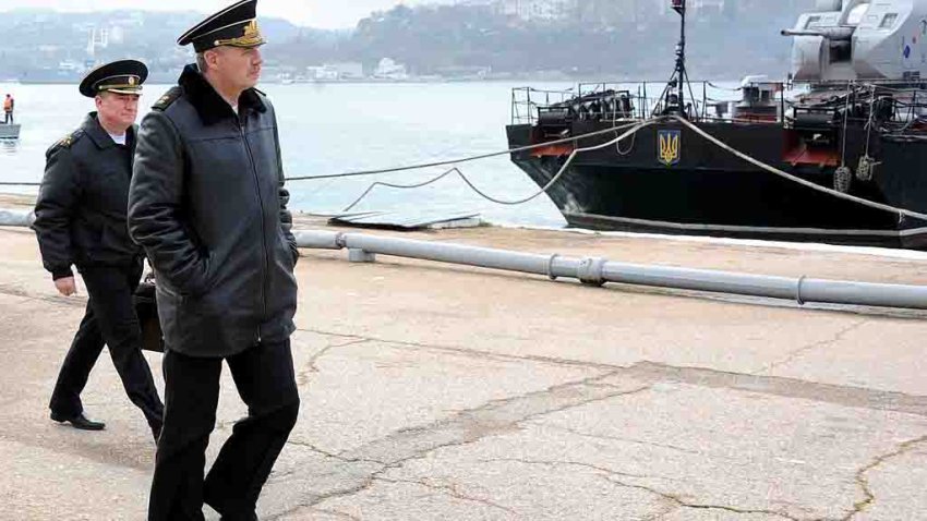 The Commander-in-chief of the Russian Black Sea Fleet Alexander Vitko (2nd L) walks in front of Ukrainian navy ships moored in the Sevastopol harbour on March 20, 2014. European leaders were today to debate biting economic sanctions against Russia for its annexation of Crimea as Ukraine tore up key ties with the Kremlin and drew up plans to evacuate its nationals from the rebel peninsula. AFP PHOTO / VIKTOR DRACHEV        (Photo credit should read VIKTOR DRACHEV/AFP via Getty Images)