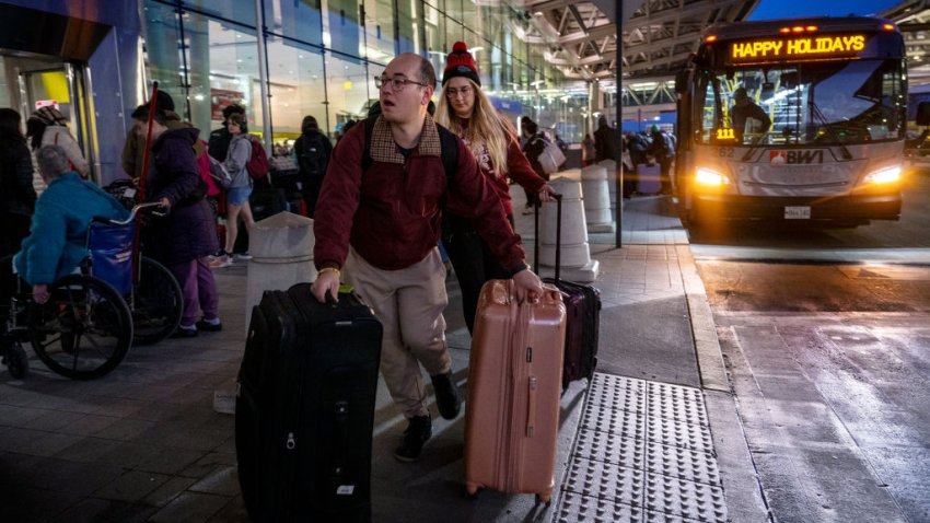 Passengers get off a bus at Baltimore/Washington International Thurgood Marshall Airport in Linthicum, Maryland, on December 22, 2023, ahead of the holiday travel rush. US airlines are gearing up for record traffic this holiday season, having beefed up staffing in the hopes of avoiding a repeat of last Christmas’s operational meltdown. Authorities expect more than 267,000 flights between December 20 and 26, with a peak of nearly 49,000 flights on December 22, according to the Federal Aviation Administration. (Photo by Jim WATSON / AFP) (Photo by JIM WATSON/AFP via Getty Images)