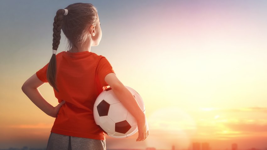 Cute little child dreams of becoming a soccer player. Girl plays football.