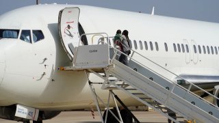 Una mujer con un niño pequeño aborda un vuelo de ICE Air de regreso a Honduras el miércoles en Harlingen, Texas.