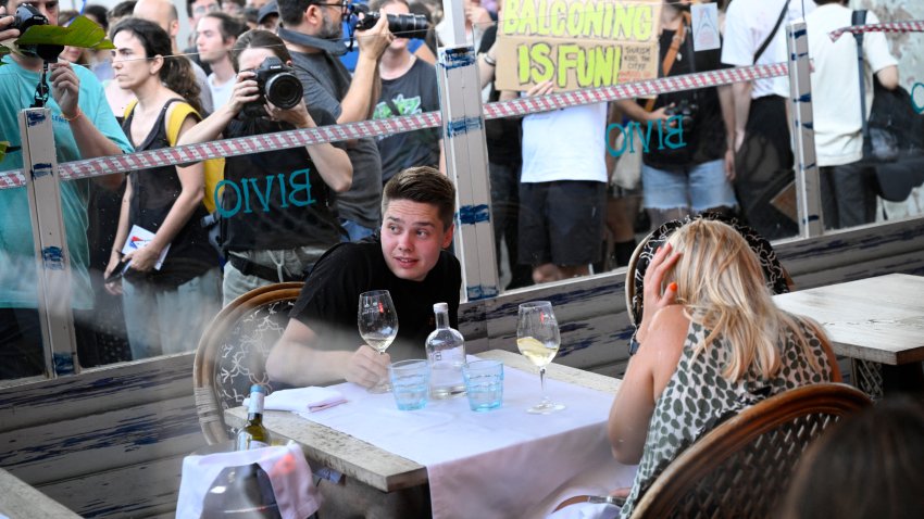 Los manifestantes colocaron un cordón simbólico en la ventana de un bar-restaurante durante una protesta contra el turismo de masas en el callejón de Las Ramblas de Barcelona, ​​el 6 de julio de 2024. Las protestas contra el turismo de masas se han multiplicado en los últimos meses en España, el segundo país más visitado del mundo.