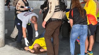 Una mujer recibe atención luego de sufrir un desmayo en el estadio Hard Rock previo al partido final entre Argentina y Colombia de la Copa América.