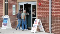 Two people walking into a polling location