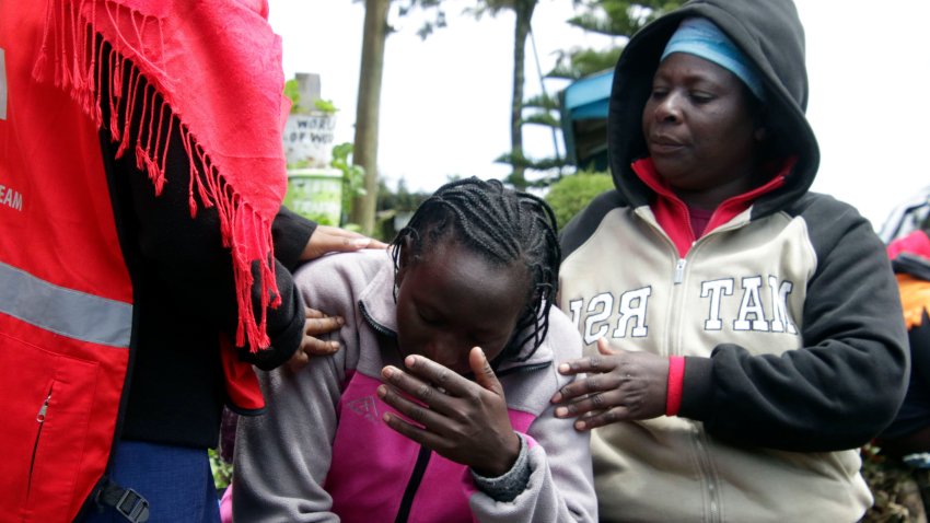 Personal de la Cruz Roja de Kenia y familiares tratan de consolar a una mujer tras un incendio en la residencia de la escuela de primaria Hillside Endarasha, en Nyeri, Kenia, el 6 de septiembre de 2024. (AP Foto)