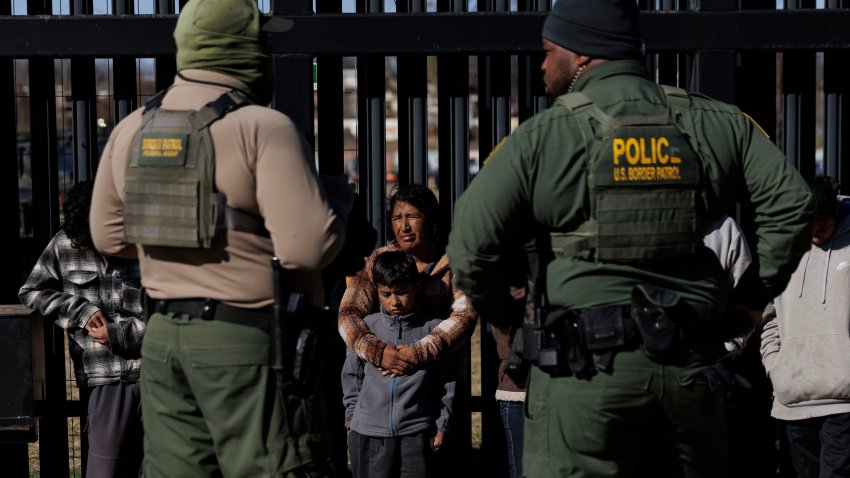 Agentes de la Patrulla Fronteriza de EEUU vigilan a los migrantes que cruzaron a Shelby Park mientras esperan a ser recogidos para su procesamiento el 4 de febrero de 2024 en Eagle Pass, Texas.