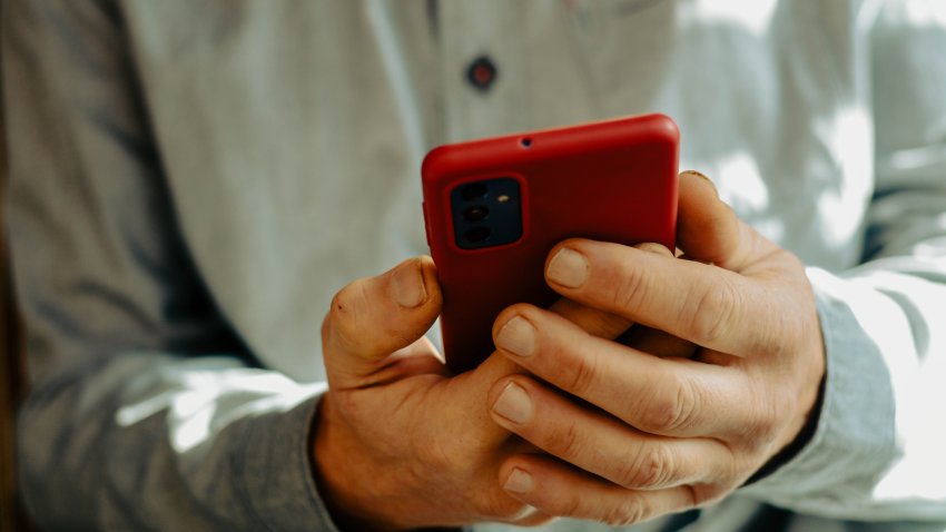 Hands hold a mobile phone