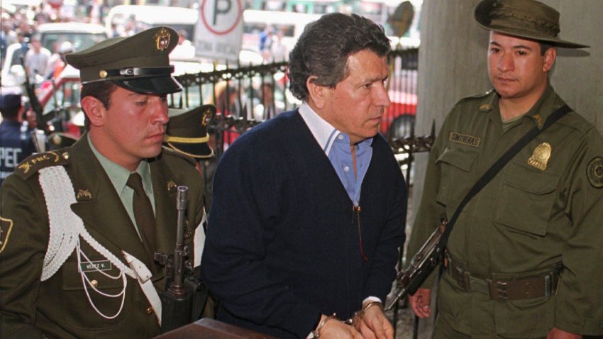 ARCHIVO – Miguel Rodríguez Orejuela, un líder del Cártel de Cali, es escoltado por policías colombianos a su entrada a la sede de la Fiscalía General en Bogotá, Colombia, en un foto de archivo de septiembre de 1996. (AP Foto/Fernando Llano, Archivo)