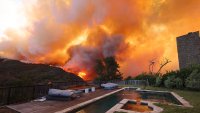 TOPSHOT – A brush fire burns near homes in Pacific Palisades, California on January 7, 2025. A fast-moving brushfire in a Los Angeles suburb burned buildings and sparked evacuations Tuesday as “life threatening” winds whipped the region. More than 200 acres (80 hectares) was burning in Pacific Palisades, a upscale spot with multi-million dollar homes in the Santa Monica Mountains, shuttering a key highway and blanketing the area with thick smoke. (Photo by David Swanson / AFP) (Photo by DAVID SWANSON/AFP via Getty Images)