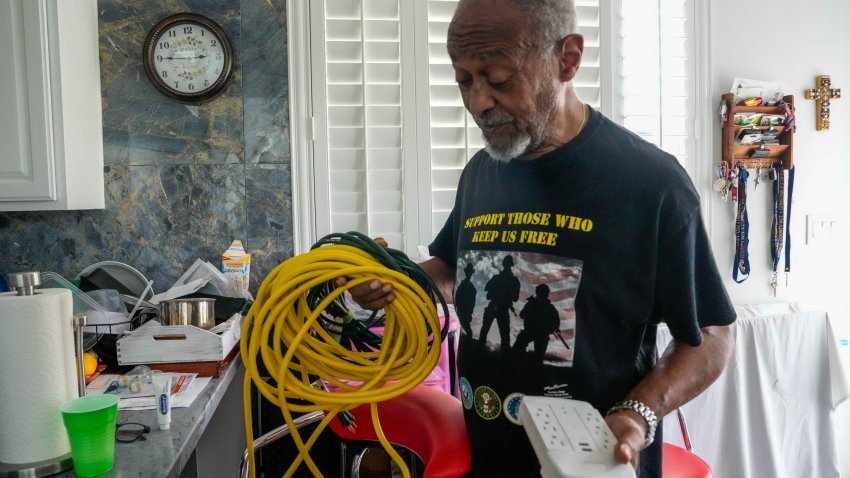 José Grinan, de 71 años, sostiene los cables de extensión que utilizó para su generador para alimentar su casa el domingo 14 de julio de 2024 en Houston, siete días después de que el huracán Beryl causara grandes cortes de energía.