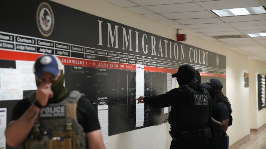 US Immigration and Customs Enforcement (ICE) agents look over lists of names and their hearing times and locations inside the Federal Plaza courthouse before making arrests on June 27, 2025 in New York. In recent weeks, there has been an uptick of immigration enforcement operations at courthouses, as thousands of migrants pursue the asylum process by attending hearings. Agents from US Immigration and Customs Enforcement (ICE) enter the court facilities unidentified, migrant advocates say, and those who do wear badges often cover their faces. Since President Donald Trump returned to power in January, ICE has been authorized to conduct enforcement activities in courts. (Photo by Bryan R. SMITH / AFP) (Photo by BRYAN R. SMITH/AFP via Getty Images)