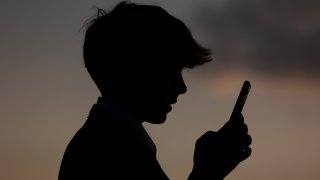 En esta ilustración fotográfica, un niño de 13 años mira la pantalla de un iPhone el 21 de mayo de 2025 en Bath, Inglaterra.